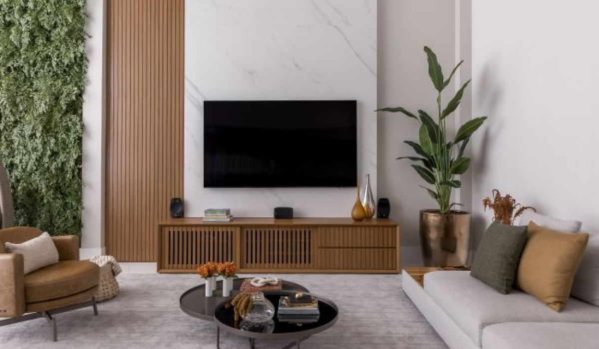 TV ganha painel de porcelanato ao longo de pé direito duplo em apartamento de 240 m²