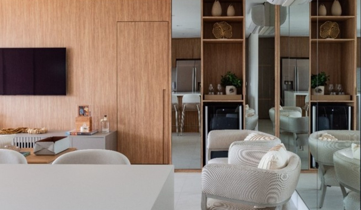 Portas mimetizadas e paleta de cores com os tons de off white e amadeirado claro dão a tônica para reforma de apartamento